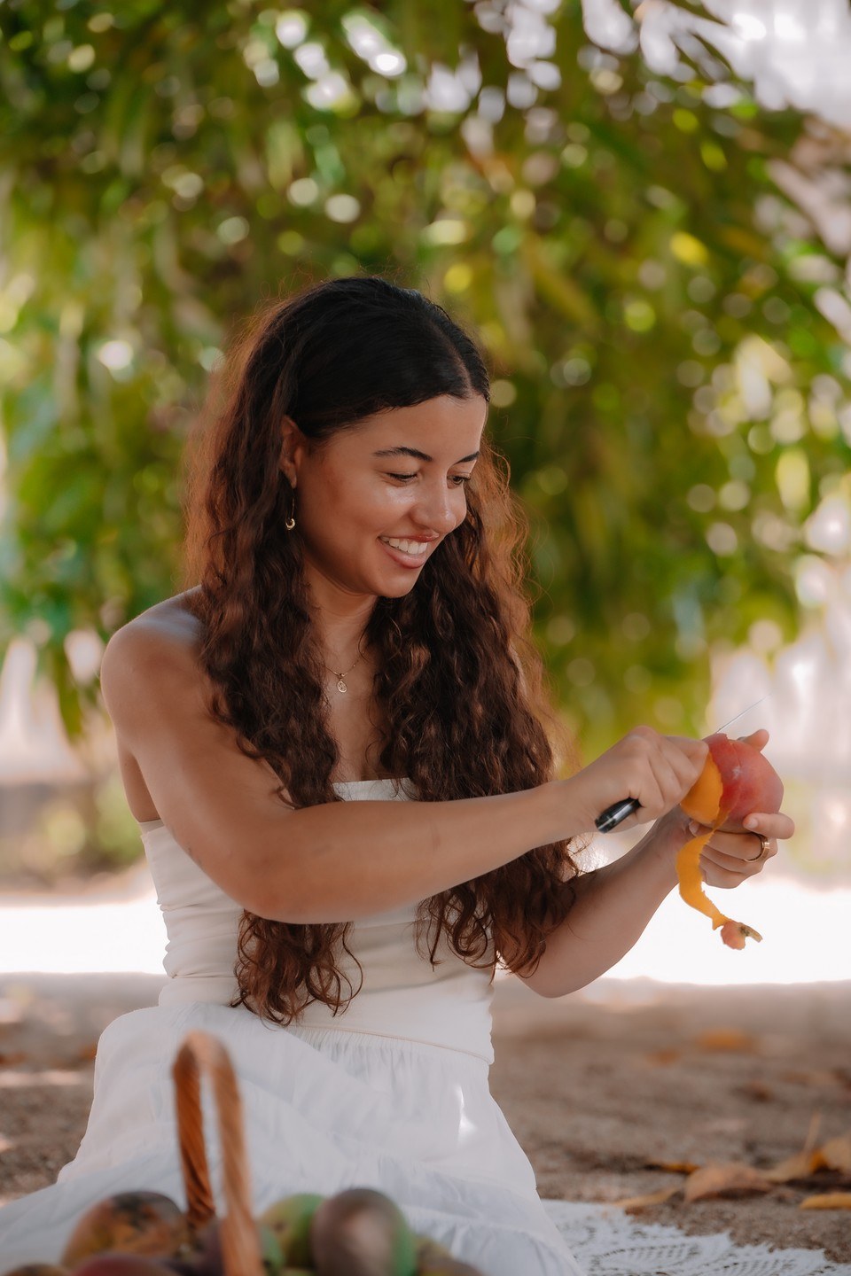 Billie peeling a mango and laughing